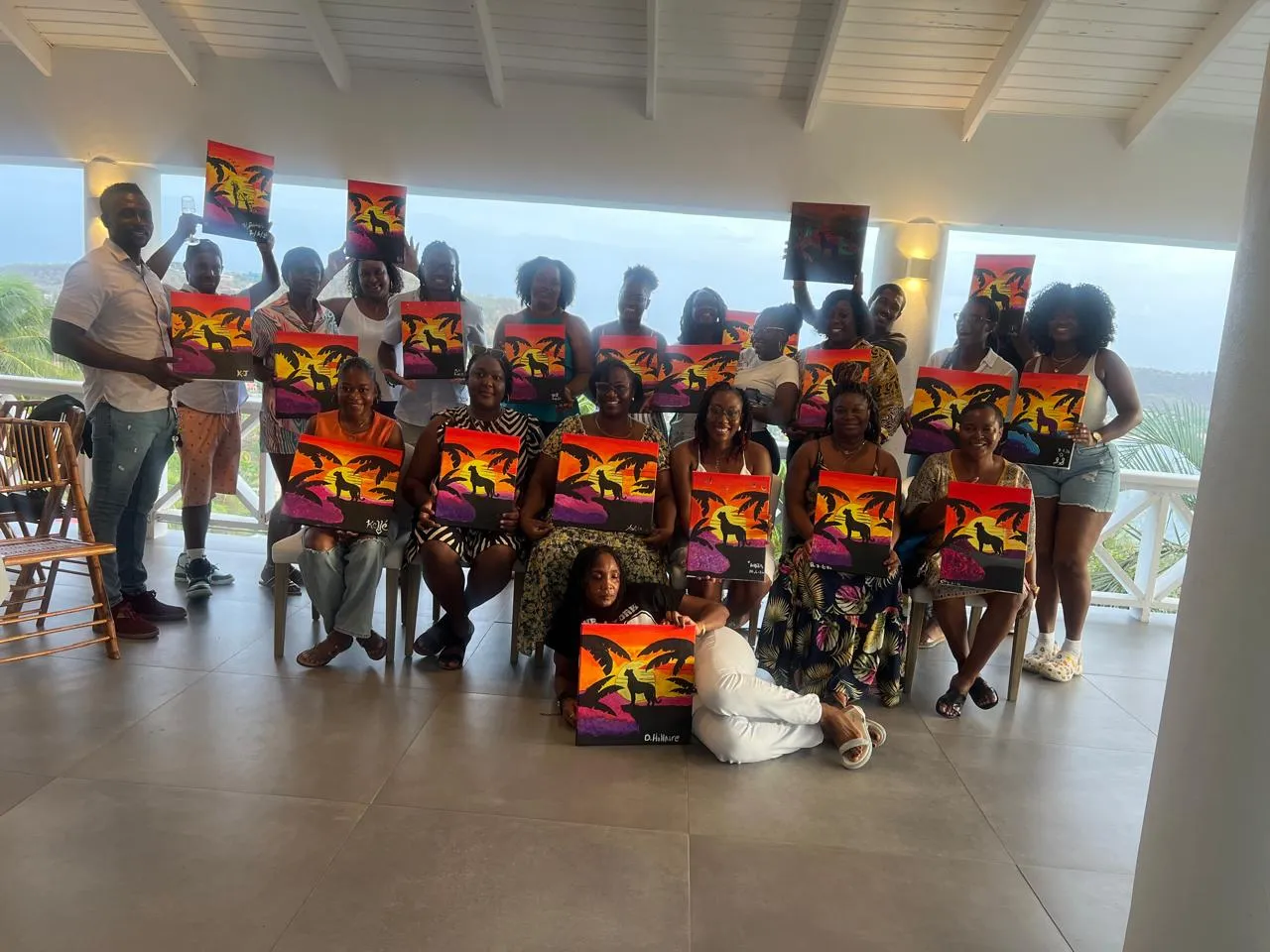 Guests holding up their finished paintings at a Corks & Canvas paint night